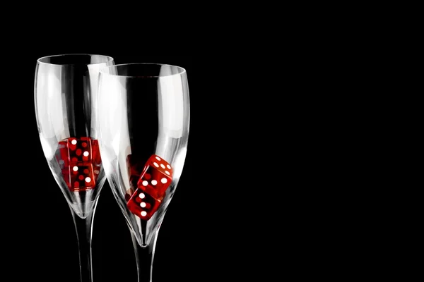 Röda tärningar i ett champagneglas — Stockfoto