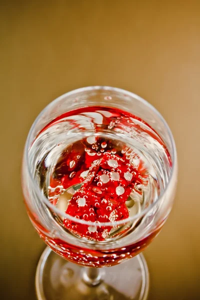 Вид сверху на красный диск в бокале шампанского — стоковое фото
