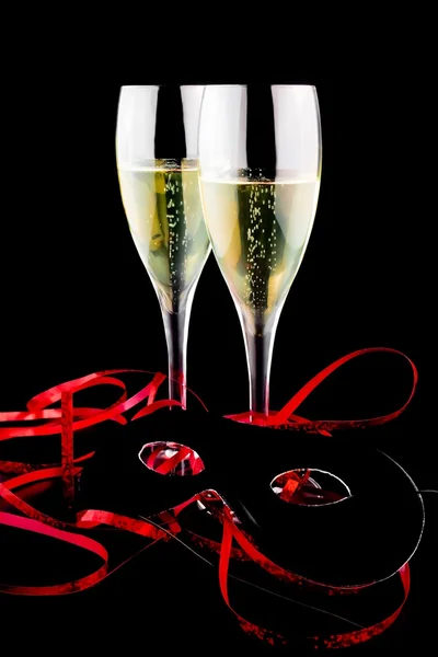 Two flutes with champagne near a carnival mask — Stock Photo, Image