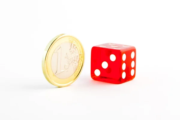 Одна монета евро и одна красная кость. — стоковое фото