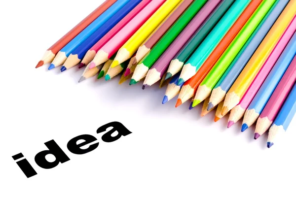 Many colored pencils near the word idea — Stockfoto