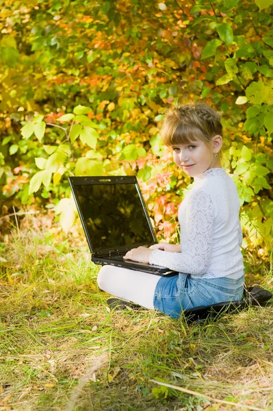 stock image Little girl with a laptop in the park