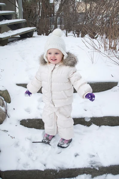 Ein süßes kleines Mädchen im Schneeanzug Stockbild