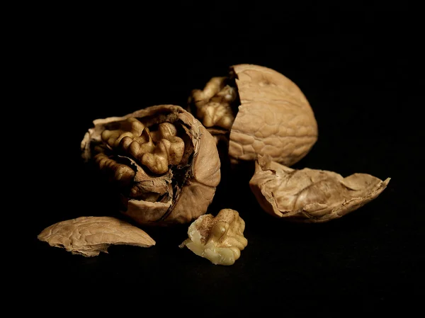 stock image Still life of walnuts on black background