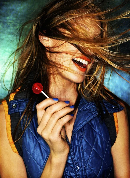 Meisje met rode lolly en haar in gezicht — Stockfoto