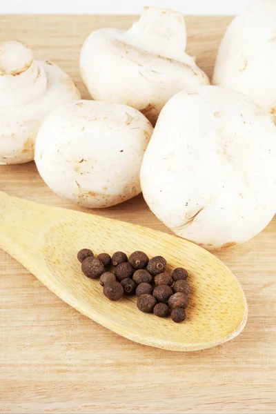 Fresh mushrooms with spoon of pepper — Stock Photo, Image