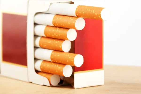 Сигарети в упаковці на дошці — стокове фото
