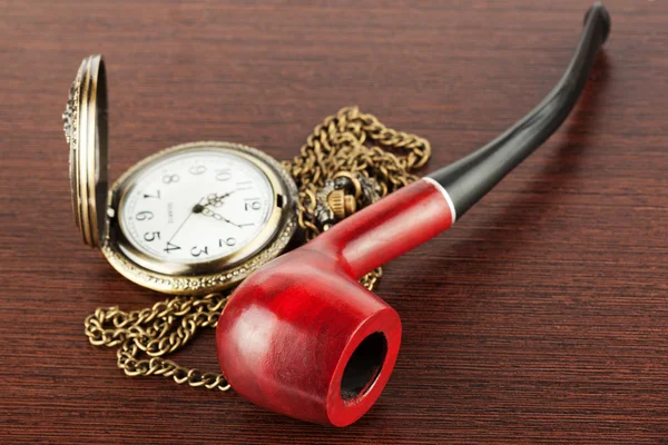 Pocket watch and smoking tube — Stock Photo, Image
