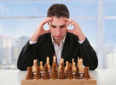 Serious man thinks on game of chess clipart