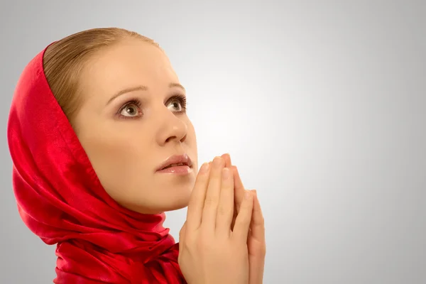 Young religious woman in a red shawl prays — Stock Photo, Image
