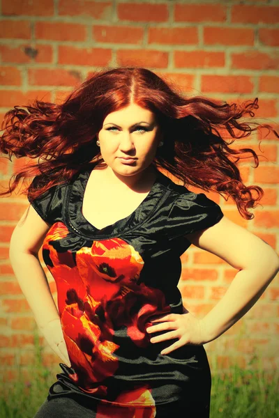 Br の赤の背景に美しいセクシーな若い赤毛の女性 — ストック写真