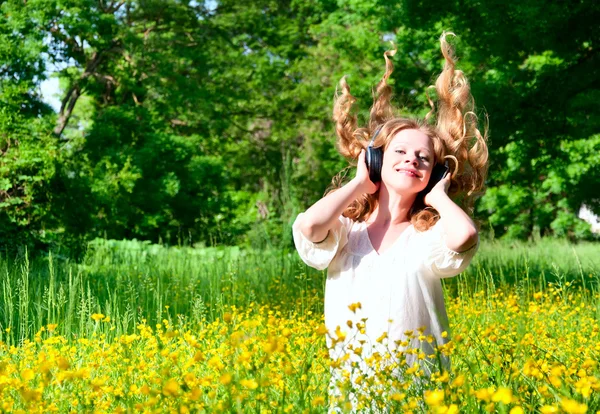 Mooi meisje in hoofdtelefoon genieten van de muziek met vloeiende hai — Stockfoto