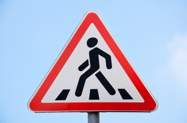 Road sign pedestrian crossing against the blue sky clipart