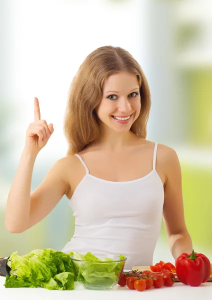 Mooi meisje met groenten in de keuken — Stockfoto