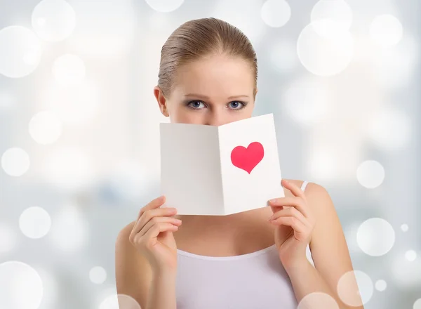 Vacker ung kvinna håller en alla hjärtans-vykort — Stockfoto