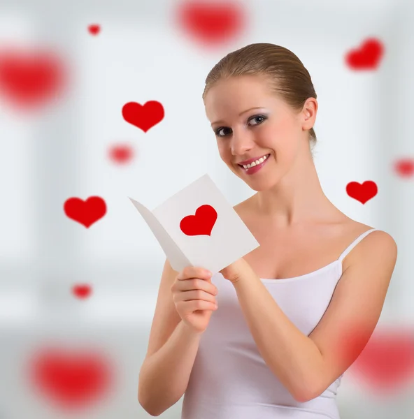 Vacker flicka med en vykort valentine — Stockfoto