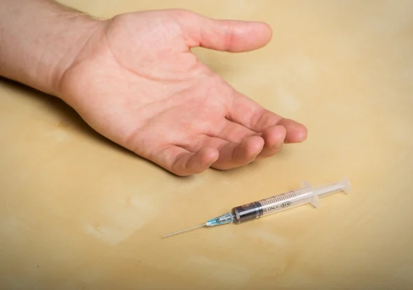 Hand addict and syringe with a drug — Stock Photo, Image