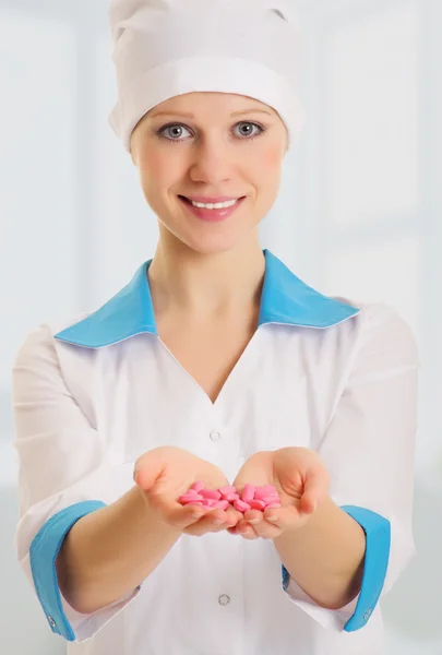 Bella infermiera con una manciata di pillole in mano — Foto Stock