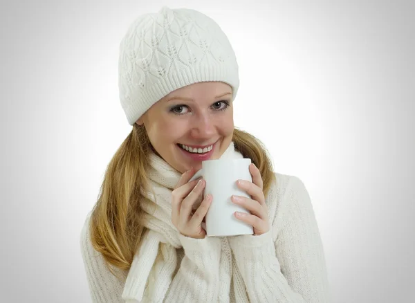 Vacker flicka i en vinter mössa och halsduk med en mugg varm dryck — Stockfoto