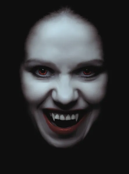 Mujer vampiro con colmillos sobre un fondo negro —  Fotos de Stock