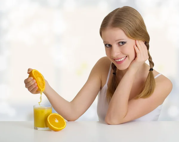 Девушка сжимает сок из апельсина — стоковое фото