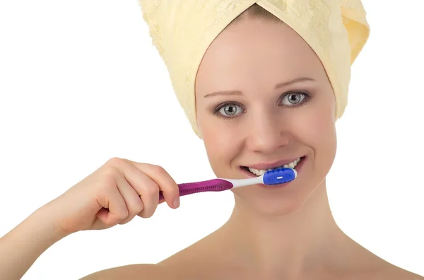 Mujer joven y saludable en una toalla limpia los dientes con un cepillo de dientes — Foto de Stock