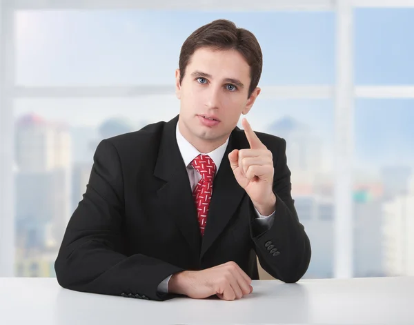 Successful business man seriously sitting at a desk in his offic — Stock Photo, Image
