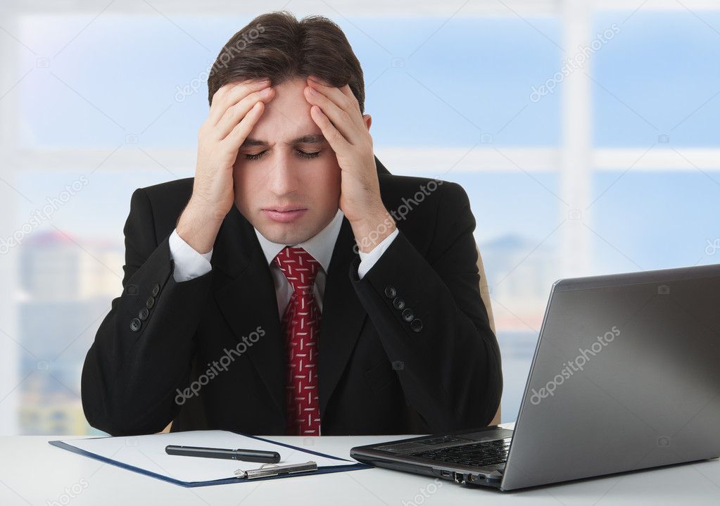 Young businessman under stress, fatigue and headache