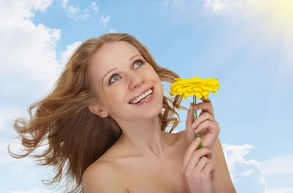 Hermosa chica con el pelo que fluye con una flor de gerberas amarillas ag —  Fotos de Stock