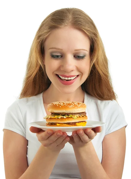 Menina feliz bonita olha para um prato de fast food, hambúrguer é — Fotografia de Stock