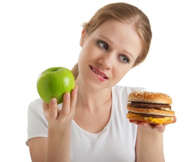 Attractive young woman makes a choice between healthy and unheal clipart