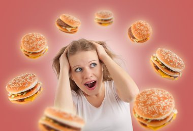 Diet concept. young woman is under stress, burgers are flying ar clipart