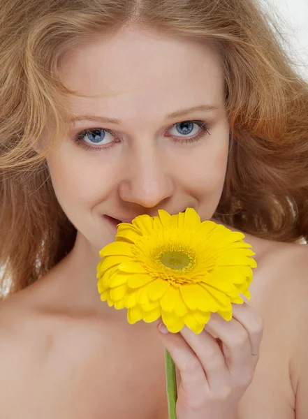 Prachtige blond meisje met een gele gerbera bloem — Stockfoto