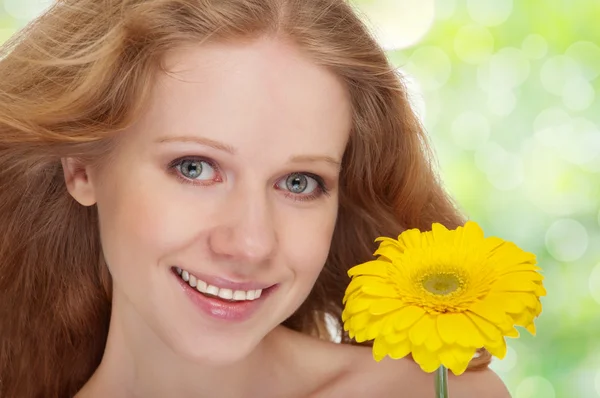 Молодая красивая блондинка с желтым цветком герберы рядом — стоковое фото