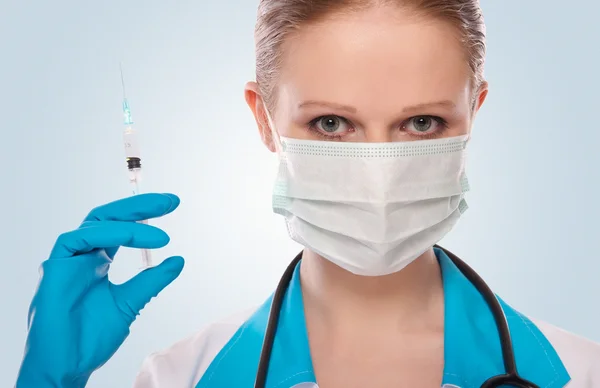 Ärztin mit Maske und Spritze mit Impfstoff — Stockfoto