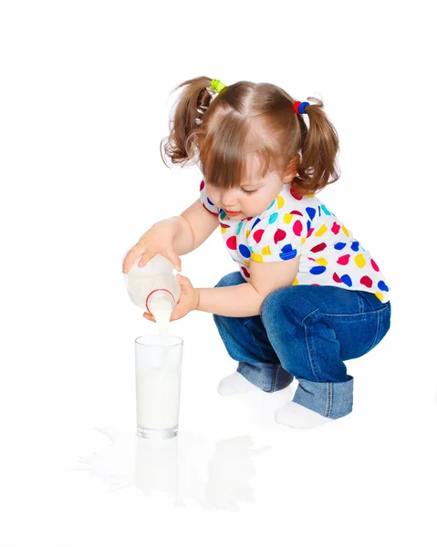 Little girl pours milk — Stock Photo, Image