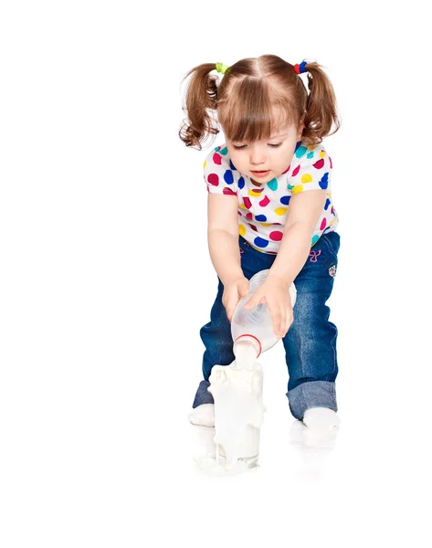Little girl pours milk — Stock Photo, Image