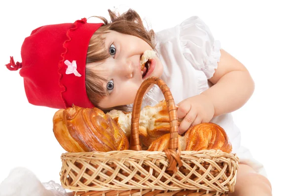 Piękne małe dziecko w czapkę jedzenia bochenka chleba — Zdjęcie stockowe
