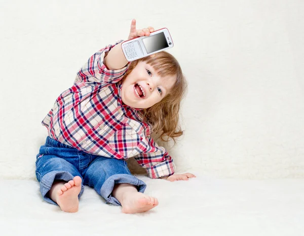 Beautiful little child holds a cell phone — Stock Photo, Image