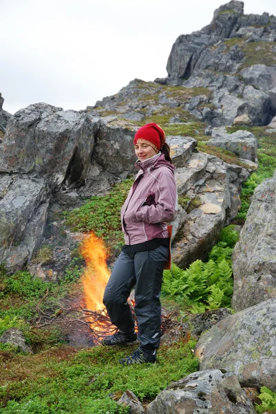 Tourist near the bonfire under the rock — Stock Photo, Image