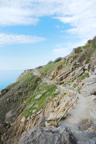 Hiking trail on slope against the sky and sea. — Stock Photo, Image