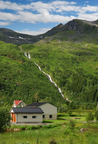 Casa bajo la montaña con cascadas . —  Fotos de Stock