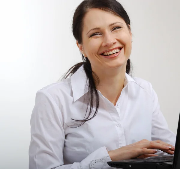 Ευτυχισμένη γυναίκα που εργάζεται με ένα φορητό υπολογιστή. — Φωτογραφία Αρχείου
