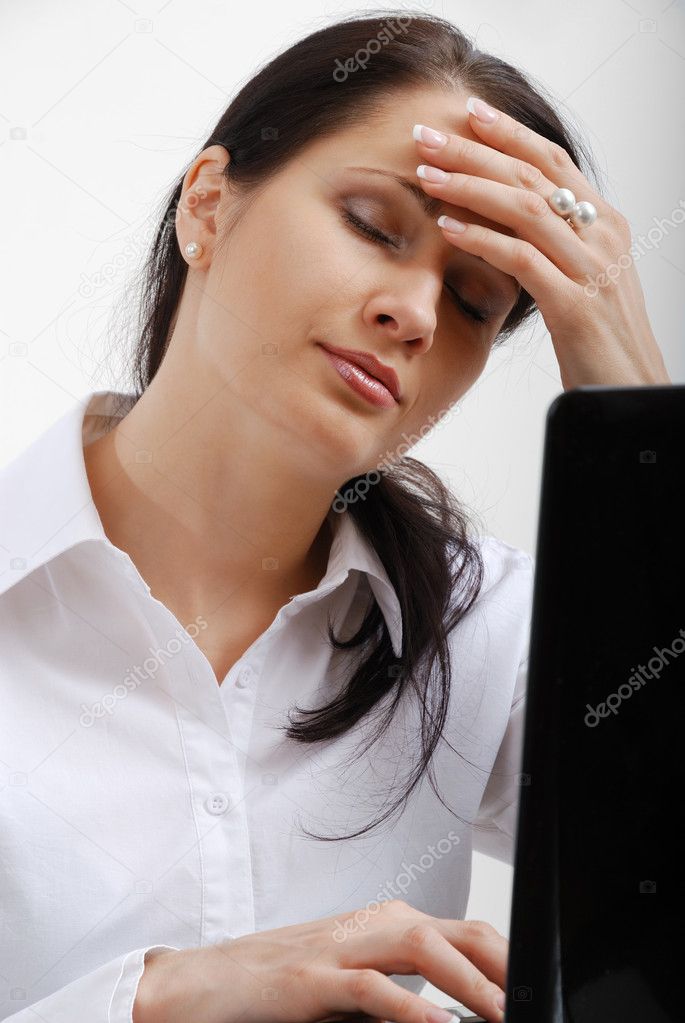 Tired woman near laptop.