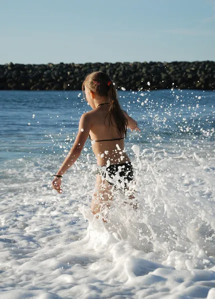 Young girl playing in the breaking waves. — Stock Photo, Image