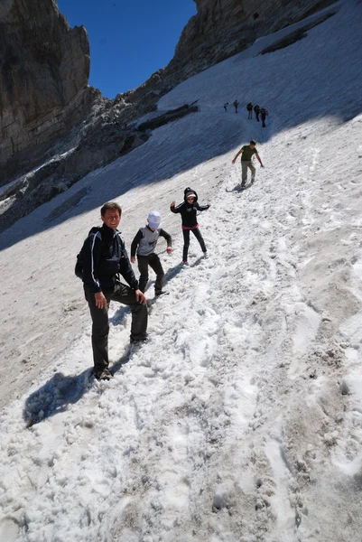 Hikers on the snowfield in summer. — Stock Photo, Image