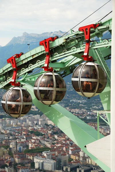 Grenoble Fransız Alp Dağları'nın eteklerinde büyük bir şehirdir. Les bulles şehrin turist taşıyan yumurta şekilli kablo arabaları vardır. — Stok fotoğraf