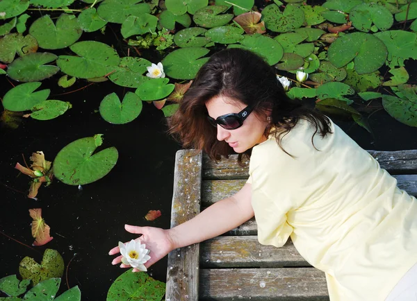 Woman near the lake with water lilies. — Stock Photo, Image