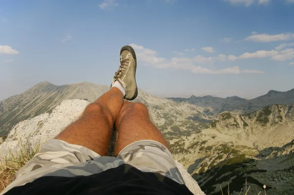 Männliche Beine entspannen sich auf dem Gipfel — Stockfoto