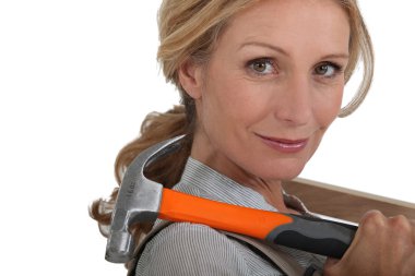 Blond woman holding hammer over shoulder clipart